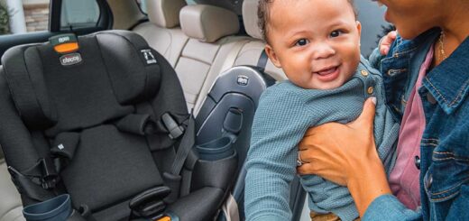 Rodzic zakładający uśmiechnięte niemowlę do fotelika samochodowego w aucie rodzinnym