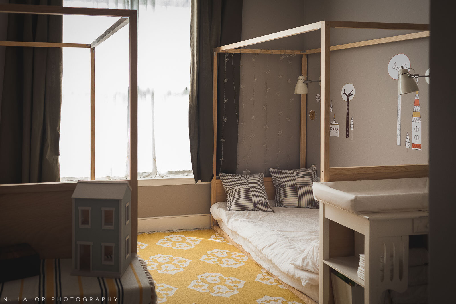 Duże stojące lustro na podłodze przed którym podziwia się swoje odbicie dziecko