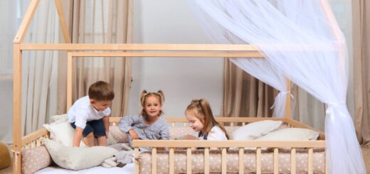 Jasny pokój dziecka z niskim łóżkiem regałami z zabawkami i bawiącym się maluchem